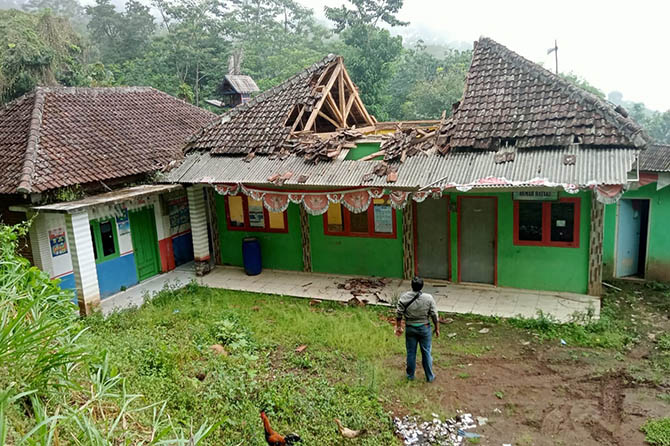 AMBRUK: Seorang warga melihat kondisi bangunan kantor Desa Tambak Ukir, Kecamatan Kotaanyar, yang atapnya ambruk. (Perangkat Desa Tambak Ukir for Radar Bromo)