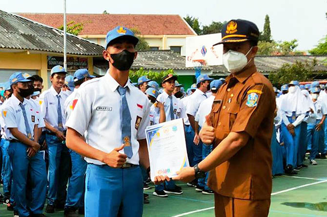 BERPRESTASI: Kepala SMAN 1 Kraksaan, Bambang Sudiarto, S.Pd, M.M.Pd menyerahkan piagam penghargaan kepada siswa yang mengukir prestasi dalam upacara Hari Kebangkitan Nasional, beberapa waktu lalu. (SMAN 1 Kraksaan for Radar Bromo)