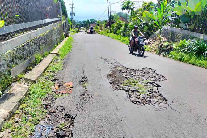 BERBAHAYA: Sejumlah pengendara melintas di Tanjakan Jerapah, Kelurahan/Kecamatan Prigen, Kabupaten Pasuruan. Sudah lama jalan ini berluban dan sejauh ini belum diperbaiki. (Foto: Rizal Fahmi Syatori/Jawa Pos Radar Bromo)