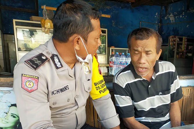 Mahfudijanto saat ngobrol dengan petugas Polsek Purwosari. (Rizal Syatori/ Radar Bromo)
