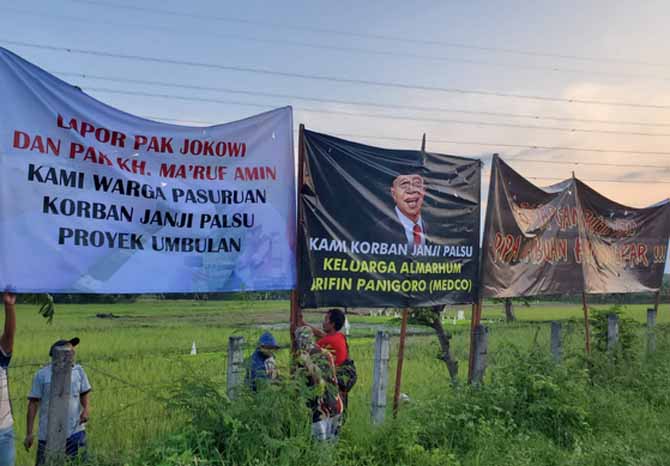 SIANG HARI: Poster yang dipasang warga soal proyek Umbulan di Desa Curahdukuh, Kraton, Rabu (11/5) siang. Nampak isi poster ikut menyinggung perusahaan dan tokoh pemiliknya. (Foto: Istimewa)