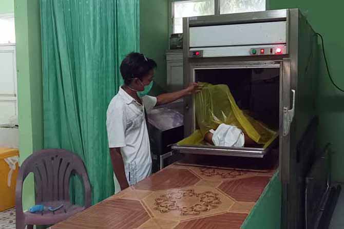 MASIH DISIMPAN: Mujino menunjukkan jenazah korban tabrak lari di Jabung Sisir, Paiton, Jumat (20/5) dini hari. (Foto: Agus Faiz Musleh/Jawa Pos Radar Bromo)