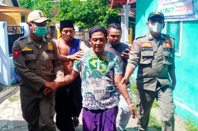 IKUT PETUGAS: Salah seorang ODGJ dibawa anggota satpol PP dari Kelurahan Pohjentrek, Kamis (19/5). (Foto: M Busthomi/Jawa Pos Radar Bromo)