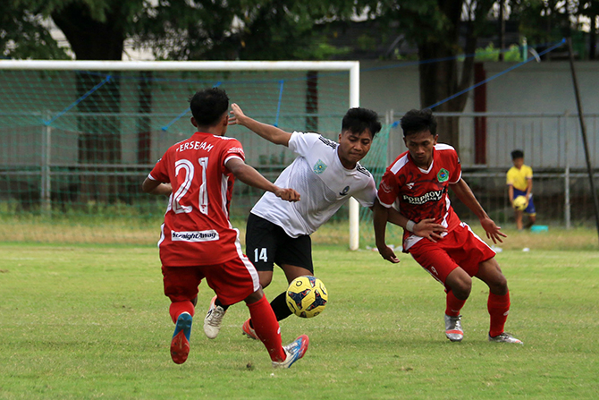 HALAU LAWAN: Pemain tengah Tim Kota Probolinggo Dana Rizky Aimar berusaha merebut bola dari Tim Kabupaten Pamekasan. (M. Zubaidilah/Jawa Pos Radar Bromo)