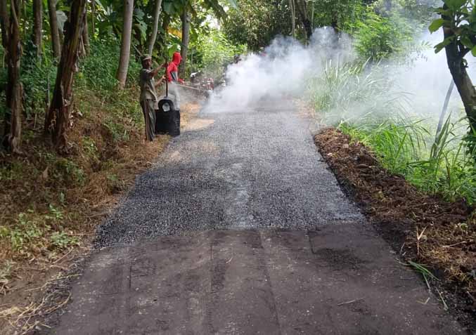 TINGKATKAN KUALITAS: Sejumlah pekerja mengaspal jalan sepanjang 510 meter di Dusun Krajan. Jalan ini memiliki volume kendaraan yang cukup tinggi. (Foto: Pemerintah Desa Blimbing for Jawa Pos Radar Bromo)