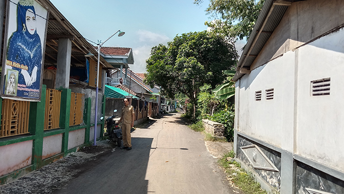 LENGKAPI SARPRAS: Kasi Pembangunan Desa Maron Kidul Harianto mengecek salah satu PJU di tengah permukiman warga. Pemerintah desa telah memasang 75 unit PJU di Dusun Brukan dan Dusun Pekalen. (Achmad Arianto/Jawa Pos Radar Bromo)