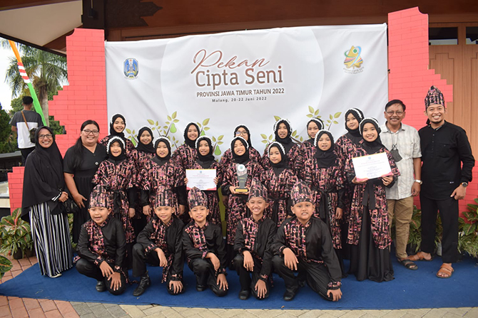 TIM PADUSA: Inilah siswa-siswi terbaik MI Muhammadiyah 1 Kota Probolinggo bersama Kepala MIM Hanafi (dua dari kanan) dan guru pembimbing foto bersama Trofi Juara 2 dan piagam penghargaan Seni Paduan Suara dalam PCS Provinsi Jawa Timur, Selasa (21/6).