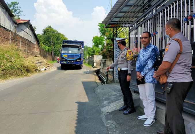 DIEVALUASI: AKP Yudhi mengamati kondisi Jalan Kaliputih, Desa Sumbersuko, Kecamatan Gempol. (Foto: Rizal F Syatori/Jawa Pos Radar Bromo)