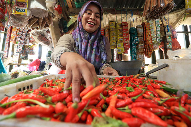 KIAN PEDAS: Pedagang cabai rawit di Pasar Bangil menunjukkan cabai dagangannya. Harga cabai di Pasuruan-Probolinggo meroket hingga nyaris setara harga daging. (Mokhamad Zubaidillah/Radar Bromo)