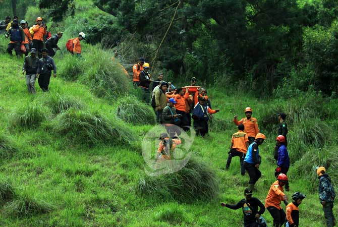 SUSAH PAYAH: Tim SAR gabungan saat mengevakuasi korban Roni Efendi dari tebing, Selasa (21/6). (Mokhamad Zubaidillah/Radar Bromo)