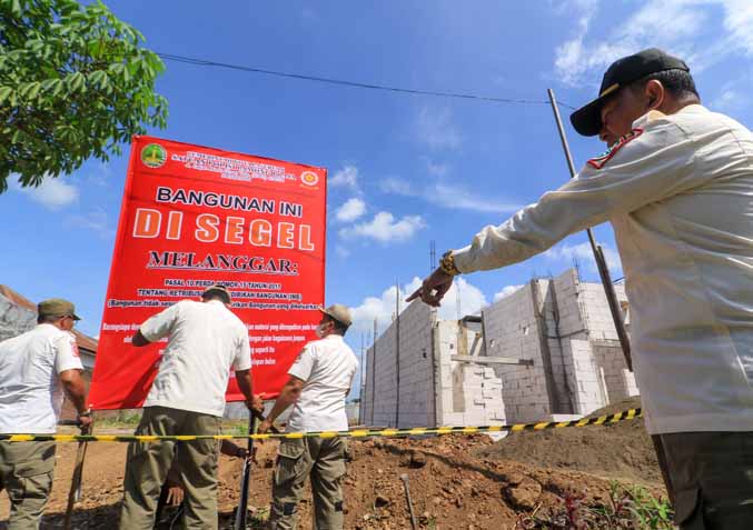 SALAHI ATURAN: Personel Satpol PP menyegel tanah kavling yang siap dibangun di Perumahan Istana Bestari, Rabu (8/6) sore. (Foto: M Zubaidillah/Jawa Pos Radar Bromo)