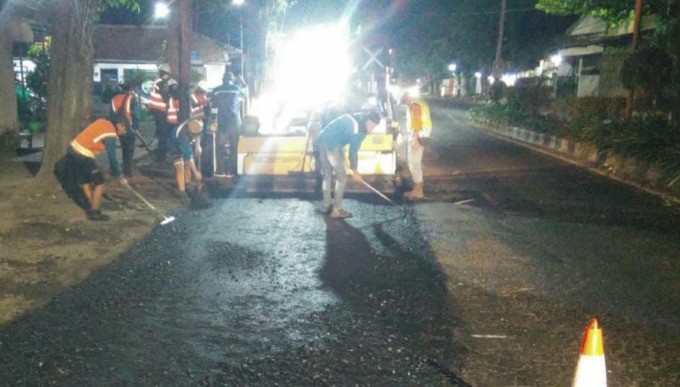 OVERLAY: Pekerja di lokasi perbaikan aspal Jalan Panglima Sudirman, Selasa (26/7) malam. (Foto: Fahrizal Firmani/Jawa Pos Radar Bromo)