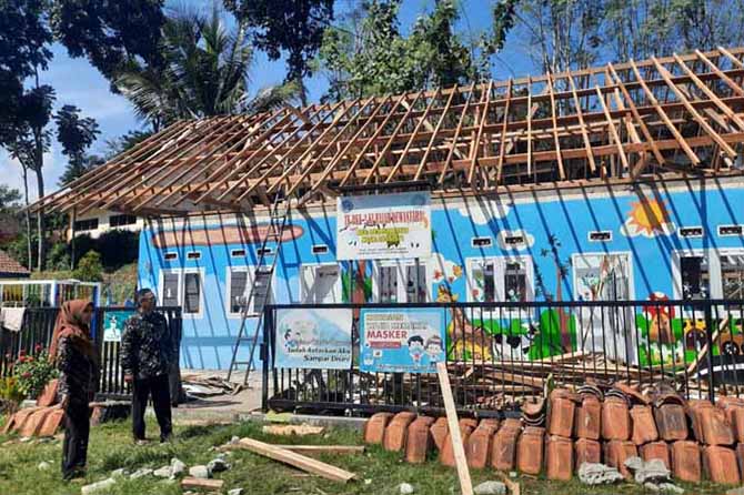 LEBIH LAYAK: Kepala Desa Lebakrejo Arimi (kiri) memantau rehab atap TK PKK Ki Hajar Dewantoro yang masih progres 45 persen. (Pemdes Lebakrejo for Radar Bromo)