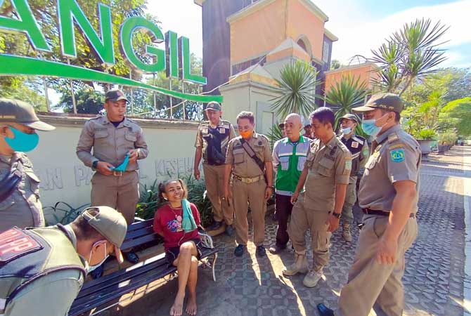 Petugas Satpol PP Kabupaten Pasuruan saat hendak mengamankan seorang ODGJ di alun-alun Bangil. (Iwan Andrik/ Radar Bromo)