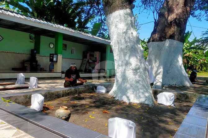ZIARAH: Taufik alias Mbah Gendeng, pemilik Padepokan Keramat saat berziarah ke makam Mbah Bangil di kawasan makam umum Kalirejo, Kecamatan Bangil, Kabupaten Pasuruan. (Foto: Iwan Andrik/Jawa Pos Radar Bromo)
