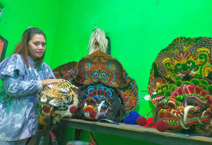 BARU DUA TAHUN: Putri Dwi Lestari, 27, ketua Sanggar Seni Tari Tradisional Putro Ragil Original menunjukkan topeng barongan di sanggar miliknya yang dibangun dua tahun lalu. (Foto: Iwan Andrik/Jawa Pos Radar Bromo)