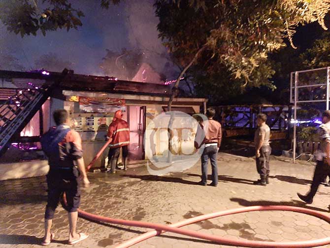 DIPICU KORSLETING: Petugas saat berupaya memadamkan api yang berkobar di ruang SKCK Mapolsek Purwosari.