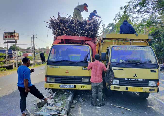 NAIK: Truk muat tebu yang menabrak median jalan, memindahkan isi muatan. (Foto: Istimewa)