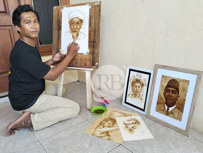 UNIK : Muhammad Hafidul Kamil melukis wajah KH. Maimun Zubair menggunakan kopi. Hasilnya mirip dengan aslinya dan juga unik. (Achmad Arianto/Jawa Pos Radar Bromo)