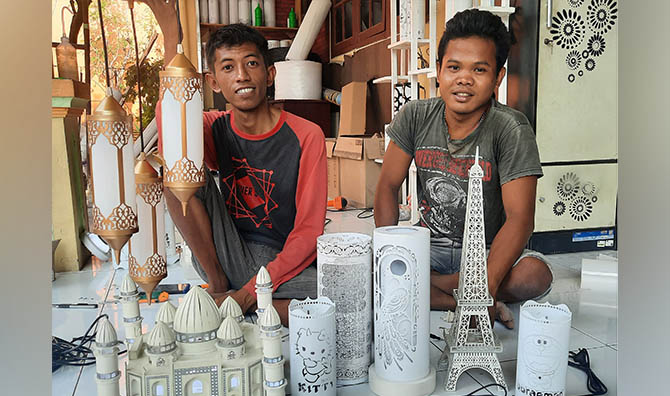 KREATIF: Erwin Andi (kiri) dan rekannya, Yozak Pamungkas di teras rumah Erwin yang jadi tempat produksi mereka. (Foto: Fahrizal Firmani/Jawa Pos Radar Bromo)