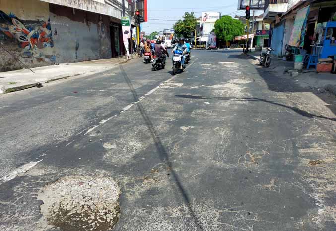 DIKELUHKAN: Sejumlah pengendara melintas di Jalan Urip Sumohardjo, Kelurahan/Kecamatan Pandaan, Kabupaten Pasuruan, yang banyak dikeluhkan warga. (Foto: Rizal Fahmi Syatori/Jawa Pos Radar Bromo)