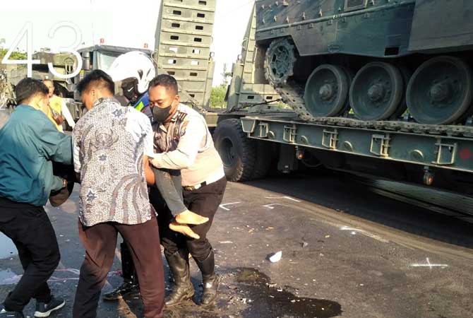 NAHAS: Petugas saat mengevakuasi jenazah pasutri yang meregang nyawa usai menabrak truk di Mangkrengan, Gejugjati, Lekok. (Satlantas Polres Pasuruan Kota for Jawa Pos Radar Bromo)