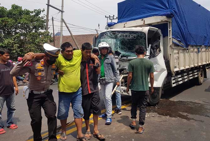 Kasatlantas Polres Pasuruan AKP Yudhi Anugerah Putra ikut mengevakuasi sopir yang sempat terjepit usai truknya terlibat tabarakan di Cangkringmalang, Beji.