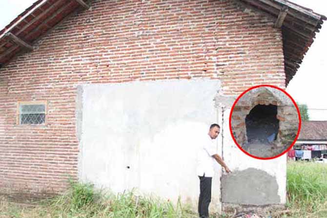 SUDAH DITAMBAL: Sahral bendahara Desa Klampokan menunjukkan tembok yang sebelumnya dilubangi pelaku (inset). (Foto: Agus Faiz Musleh/Jawa Pos Radar Bromo)