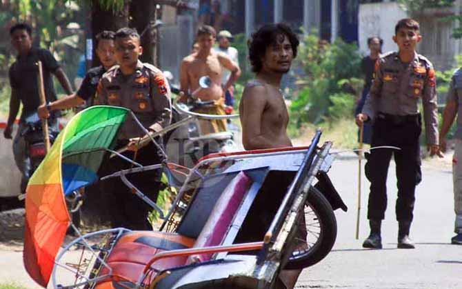 JUNGKIR WALIK: Thoriq yang membawa sajam usai membalikkan becak bermotor. (Foto: M. Zubaidillah/Jawa Pos Radar Bromo)