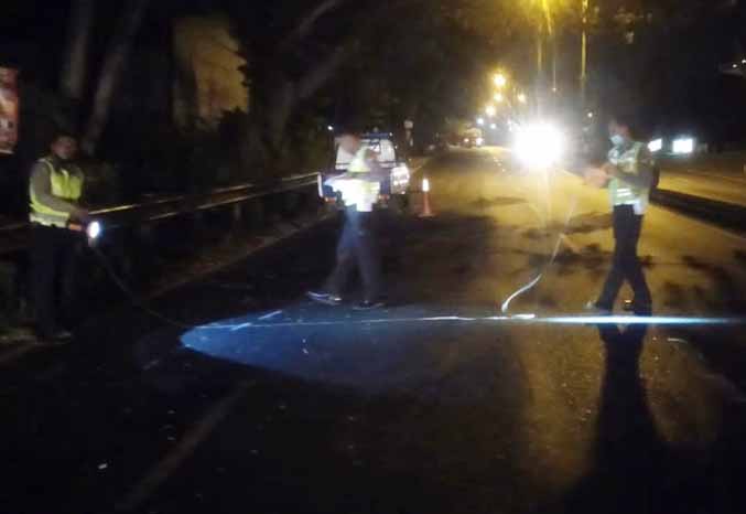 LOKASI KEJADIAN: Personel Satlantas menandai lokasi jalan raya Purwoadi tepatnya di desa Sentul, Minggu (25/9) malam. Di jalan inilah korban mengalami kecelakaan. (Foto: Istimewa)