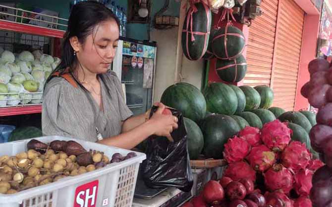 SEGAR-MANIS: Ika Iriani Marsinta, 25 melayani pembeli di Pasar Kebonagung. Sampai Minggu (9/10), buah dagangannya masih diburu pembeli. (Foto: Fuad Alyzen/Jawa Pos Radar Bromo)