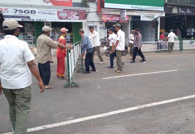 DIGESER: Sejumlah petugas menggeser pagar parkir di depan Masjid Jamik Al Anwar, Kota Pasuruan, Kamis (27/10). (Foto: Satpol PP for Jawa Pos Radar Bromo)