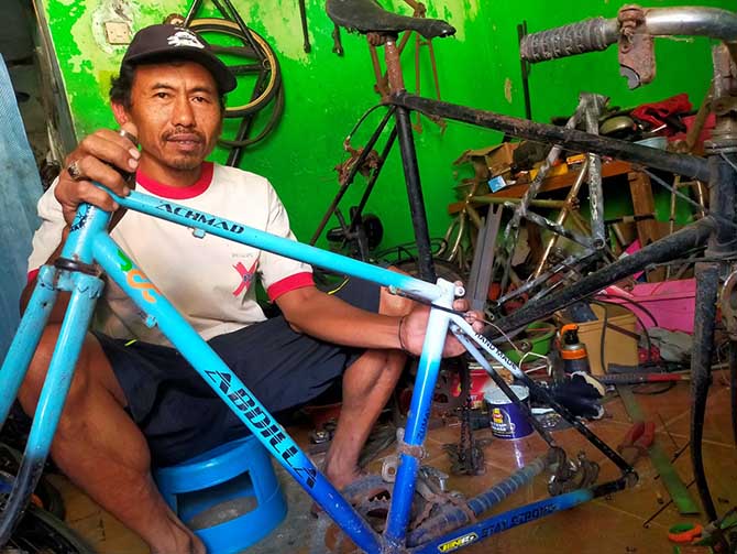 Jumadi saat merestorasi sepeda balap jadul pesanan orang. (Iwan Andrik/ Radar Bromo)