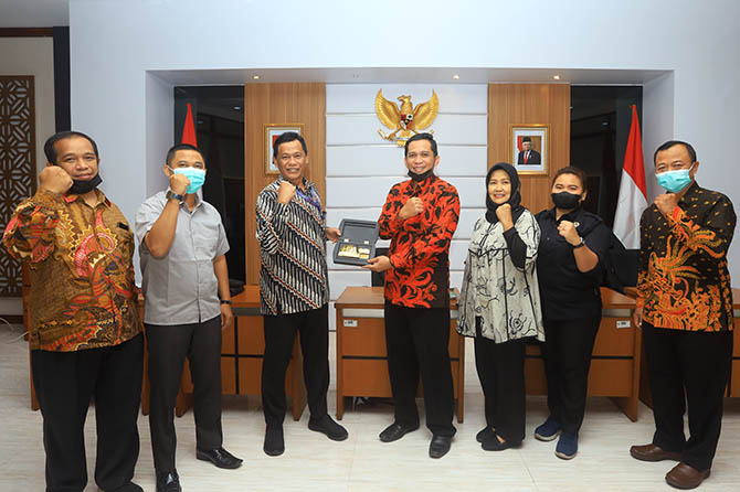 PERERAT HUBUNGAN: Kepala BKPSDM Kabupaten Probolinggo Hudan Syarifudin, S.Sos., M.Si., menyerahkan cinderamata kepada Pranata Humas Madya Subagyo di Ruang Rapat Mawar BKN. (Foto: Zainal Arifin/Jawa Pos Radar Bromo)