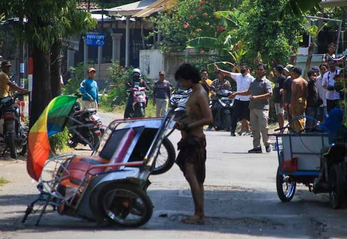 SAAT MENGAMUK: Thoriq hendak diamankan aparat saat berkeliling kampung sambil membawa senjata tajam pada akhir September lalu. (Foto: dok Jawa Pos Radar Bromo)