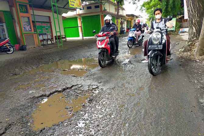SEGERA DIPERBAIKI: Sejumlah pengendara melintas di jalan jurusan Kebonwaris-Tunggulwulung, Kecamatan Pandaan, Kabupaten Pasuruan, yang kini masih rusak. (Foto: Rizal F. Syatori/Jawa Pos Radar Bromo)