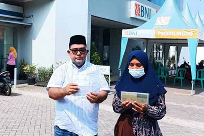 DATANGI BANK: Mulyana (kanan) bersama Mustofa saat memperlihatkan kartu deposito usai mendatangi bank, Rabu (2/11) pagi. (Foto: Agus Faiz Musleh/Jawa Pos Radar Bromo)