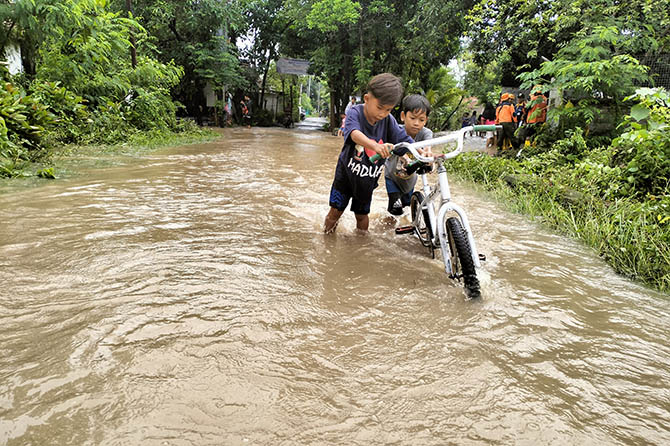 BANJIR: Ruas jalan Desa Rangkang, Kraksaan banjir akibat akibat sungai Kertosono meluap. (Achmad Arianto/Jawa Pos Radar Bromo)