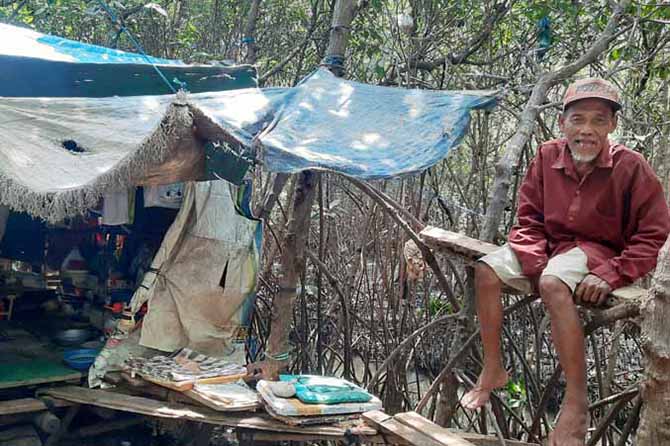 SEBATANG KARA: Agus Sugiarto dan gubuknya yang ada di hutan mangrove Mayangan. (Foto: Fahrizal Firmani/Jawa Pos Radar Bromo)