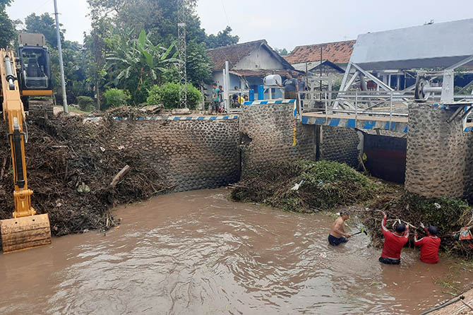 BERSIH-BERSIH: Sejumlah petugas membersihkan Dam Kelep, di Kelurahan Pohsangit Kidul, Kecamatan Kademangan, yang sempat tersumbat sampah. (Fahrizal Firmani/Jawa Pos Radar Bromo)