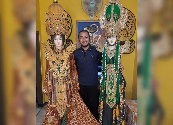 SELALU BARU: Yordan Setiawan  dan dua kostum karnaval kreasinya. (Fahrizal Firmani/ Radar Bromo)