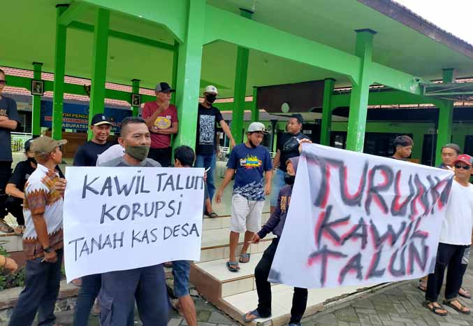PROTES: Pengunjuk rasa mendatangi kantor Desa Gununggangsir, Kecamatan Beji, dengan membawa berbagai poster Senin (28/11) pagi. (Foto: Iwan Andrik/Jawa Pos Radar Bromo)