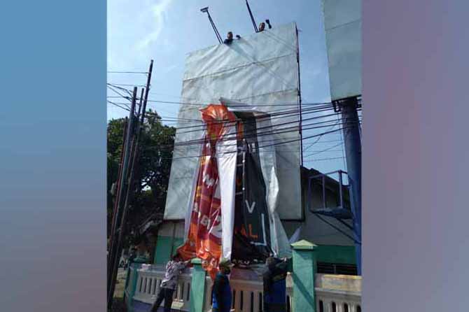 DITERTIBKAN: Satpol PP melucuti dua baliho di simpang empat dr R Soedarsono, Jumat (4/11) pagi. (Foto: Satpol PP for Jawa Pos Radar Bromo)