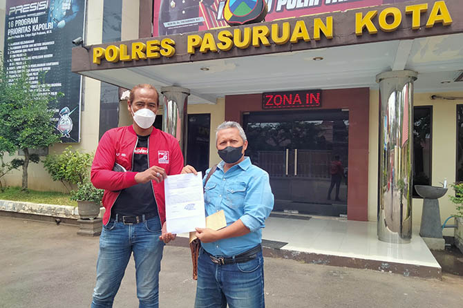 TUNTUT KEJELASAN: Indra Bayu (kanan) menunjukkan bukti laporan ke Polres Pasuruan Kota Sabtu (5/11). Dia menunggu tanggapan satpol PP. (Muhamad Busthomi/Radar Bromo)