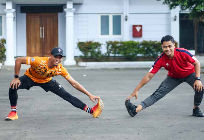 BIAR SEHAT: Gaya Aldy Syapuro Widiyanto dan Lalu Ramadi Wanda Maxudi saat berolahraga di pendapa. (Foto: M Zubaidillah/Jawa Pos Radar Bromo)