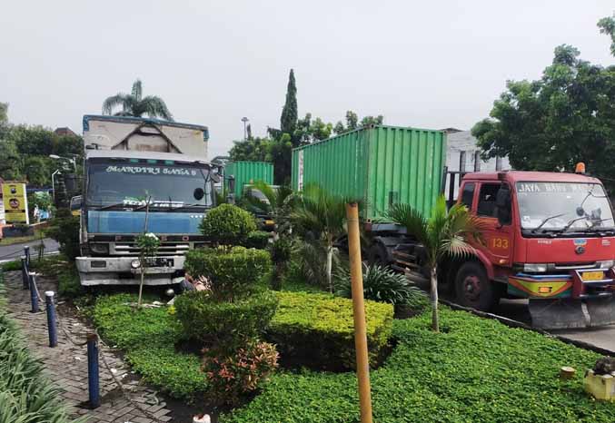 AKIBAT MENGANTUK: Tronton boks yang naik median dan taman di depan Mapolsek Pandaan, Kelurahan Petungasri, Kecamatan Pandaan. (Foto: Rizal F Syatori/Jawa Pos Radar Bromo)