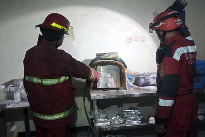 Petugas mengecek oven di kedai kopi Janji Jiwa yang terbakar.
