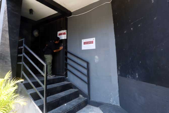 DISEGEL LAGI: Seorang warga berada di depan pintu utama Karaoke 88, yang disegel Satpol PP Kota Probolinggo. (Zainal Arifin/ Radar Bromo)