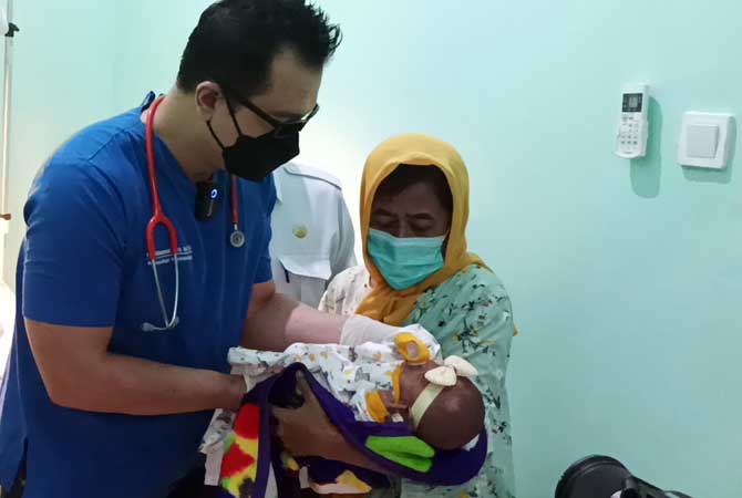 DISERAHKAN KE KELUARGA: Dokter Reza menggendong bayi Jeje dan menyerahkan kepada neneknya.