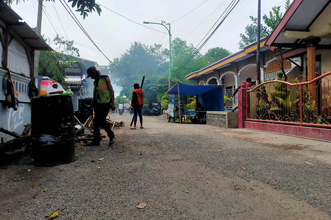 AKHIRNYA: Pekerja sedang memperbaiki Jalan Manggis di lingkungan Lumpang Bolong, Kelurahan Dermo, Kecamatan Bangil, Rabu (30/11). Jalan diaspal lagi. (Foto: Iwan Andrik/Jawa Pos Radar Bromo)
